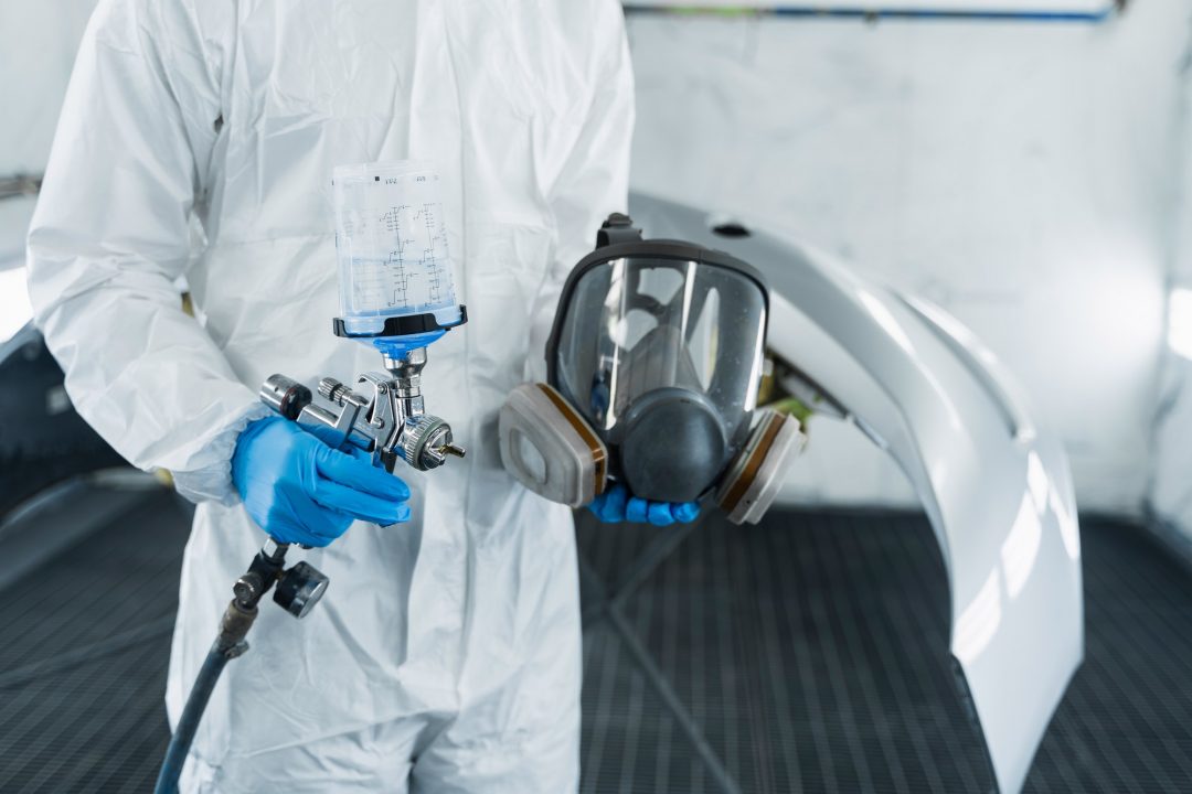 lose-up-view-of-car-painter-with-paint-gun-and-protective-respirator-in-hands-.jpg